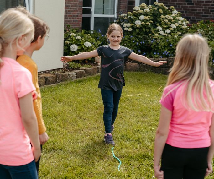 Kinder balancieren auf einem auf dem boden liegendem Seil für mehr Focus